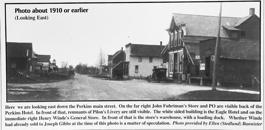 Photo about 1910 or earlier (Looking East). Here we are looking east down the Perkins main street. On the far right John Fuhriman's Store and PO are visible back of the Perkins Hotel. In front of that, remnants of Pilon's Livery are still visible. The white sided building is the Eagle Hotel and on the immediate right Henry Winde's General Store. In front of that is the store's warehouse, with a loading dock. Whether Winde had already sold to Joseph Gibbs at the time of this photo is a matter of speculation. Photo provided by Ellen (Stedlund) Bannister